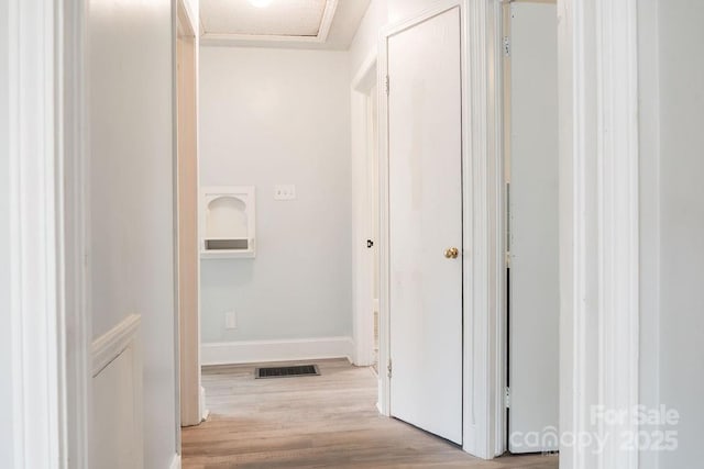 corridor with visible vents, wood finished floors, and baseboards