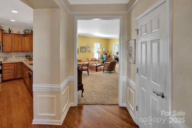 hall featuring recessed lighting, light wood-style floors, baseboards, and ornamental molding