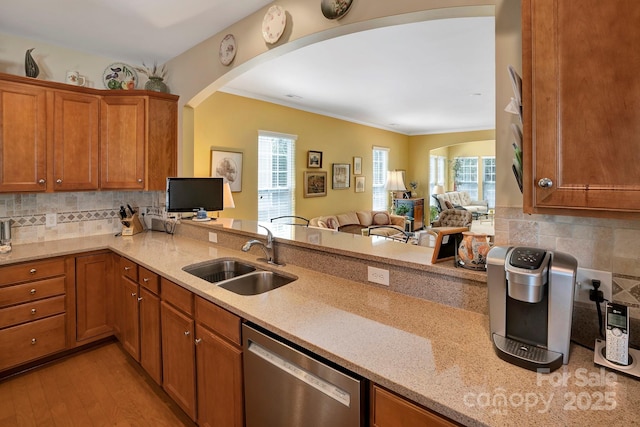 kitchen featuring a sink, brown cabinets, dishwasher, and a healthy amount of sunlight