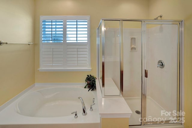 full bath featuring a shower stall and a garden tub