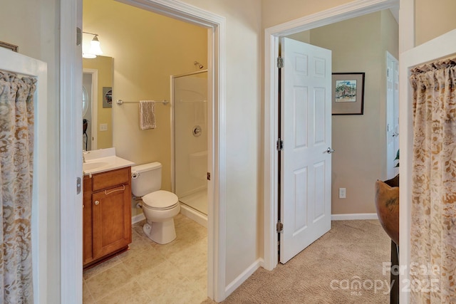 bathroom featuring vanity, toilet, baseboards, and a stall shower