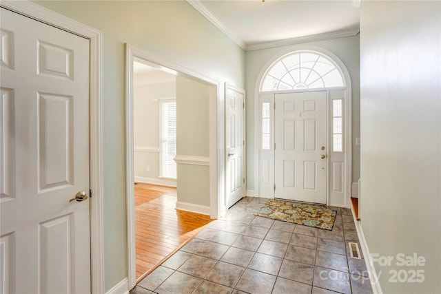 entrance foyer featuring light tile patterned floors, baseboards, visible vents, and ornamental molding