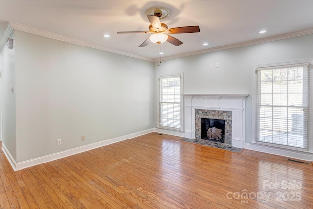 unfurnished living room featuring a ceiling fan, visible vents, a wealth of natural light, and light wood-type flooring