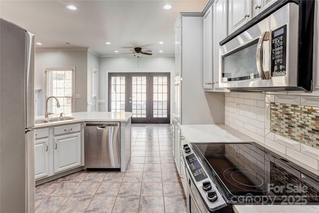 kitchen with tasteful backsplash, ceiling fan, french doors, stainless steel appliances, and a sink