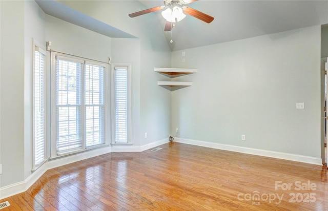 unfurnished room featuring visible vents, light wood-type flooring, a wealth of natural light, and ceiling fan