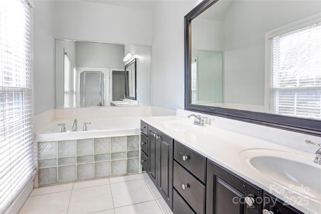 full bath with tile patterned flooring, a garden tub, a wealth of natural light, and a sink