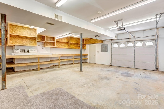 garage featuring electric panel, visible vents, and a garage door opener