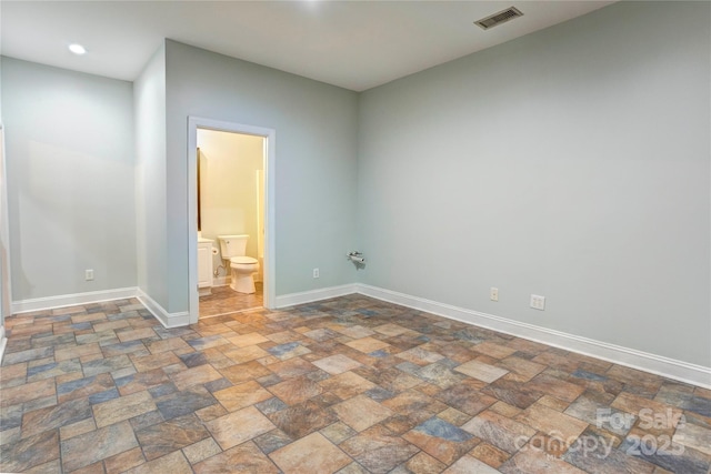 empty room featuring visible vents, baseboards, and stone finish flooring