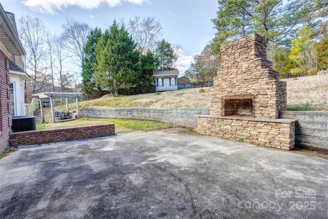 view of patio featuring cooling unit, an outdoor stone fireplace, and a pergola