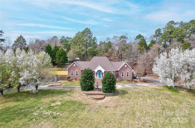 view of front facade with driveway, a front lawn, and fence