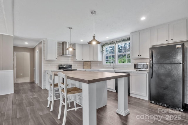 kitchen with white cabinetry, black appliances, wall chimney exhaust hood, and dark wood-type flooring