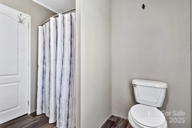 full bath featuring a shower with shower curtain, toilet, and wood finished floors