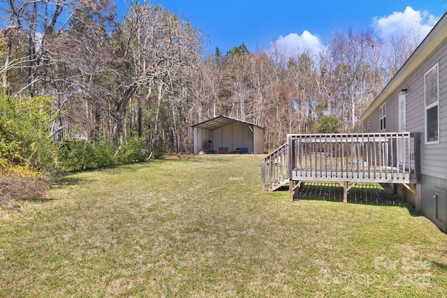 view of yard with a wooden deck and a carport