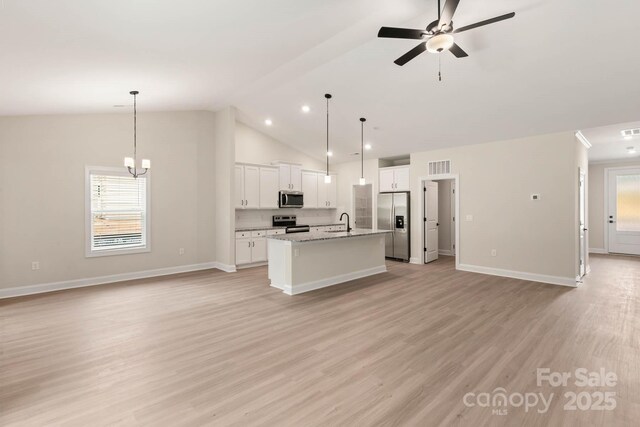 kitchen with open floor plan, an island with sink, light wood-style floors, stainless steel appliances, and a sink