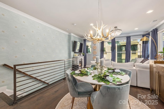 dining room with visible vents, a notable chandelier, wood finished floors, and wallpapered walls