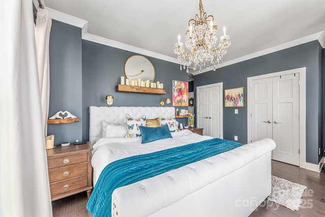 bedroom with multiple closets, a notable chandelier, wood finished floors, and crown molding