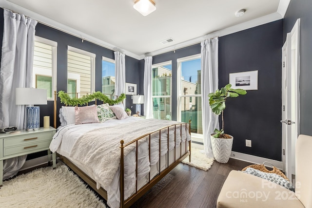 bedroom featuring visible vents, baseboards, and wood finished floors