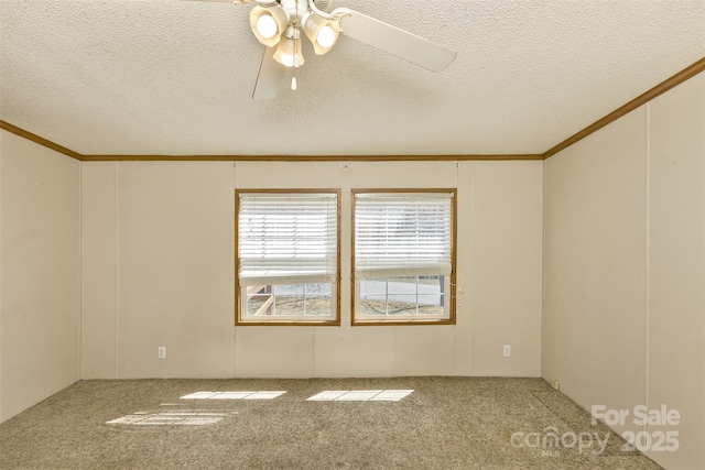 spare room featuring a textured ceiling, carpet flooring, ceiling fan, and crown molding