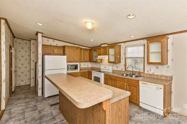 kitchen featuring a sink, a kitchen island, under cabinet range hood, white appliances, and ornamental molding