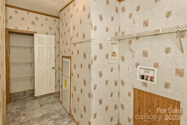 bathroom with wallpapered walls, crown molding, and a textured ceiling