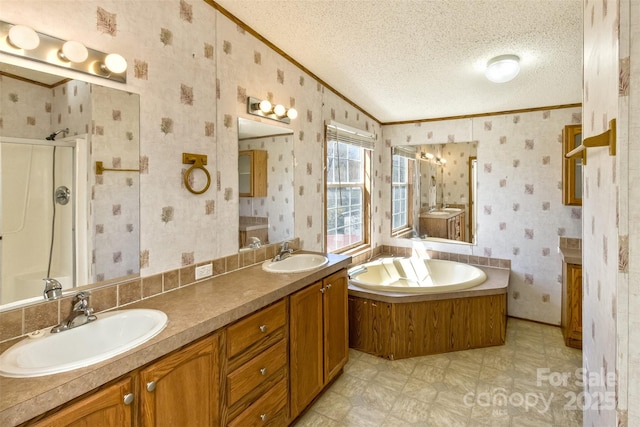 bathroom with a sink, a textured ceiling, and wallpapered walls