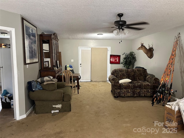 carpeted living area with ceiling fan and a textured ceiling