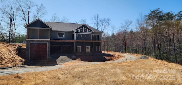 exterior space with stone siding, driveway, and a sunroom