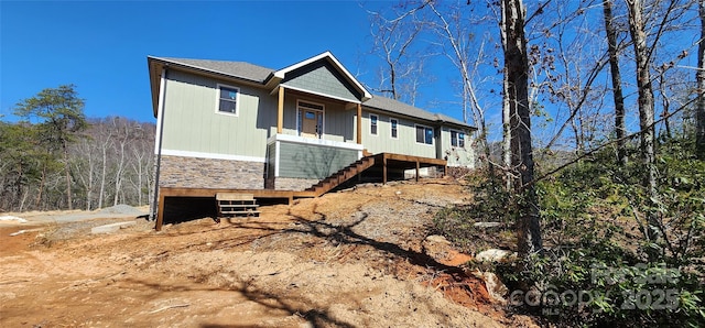 view of front of property featuring stairway and stone siding