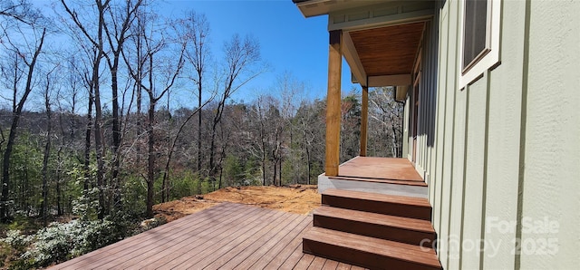 wooden terrace with a wooded view