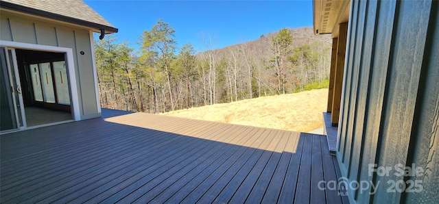 wooden terrace featuring a forest view