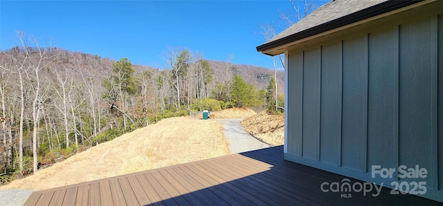 wooden deck featuring a forest view