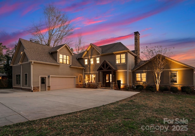 view of front of house featuring stone siding, an attached garage, and concrete driveway