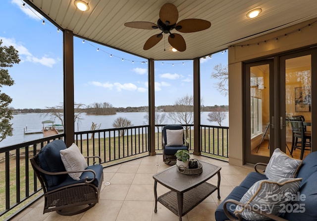 sunroom with a baseboard radiator, a water view, and a ceiling fan