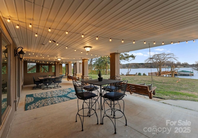 view of patio / terrace with outdoor dining area and a water view