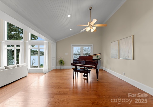 living area featuring high vaulted ceiling, baseboards, a ceiling fan, and wood finished floors