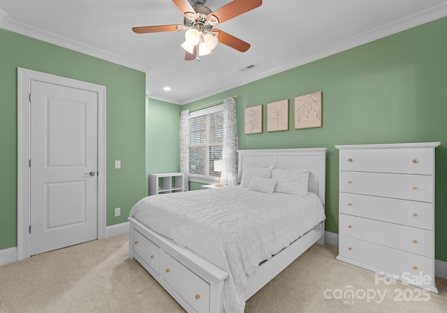 carpeted bedroom with visible vents, baseboards, ornamental molding, and a ceiling fan