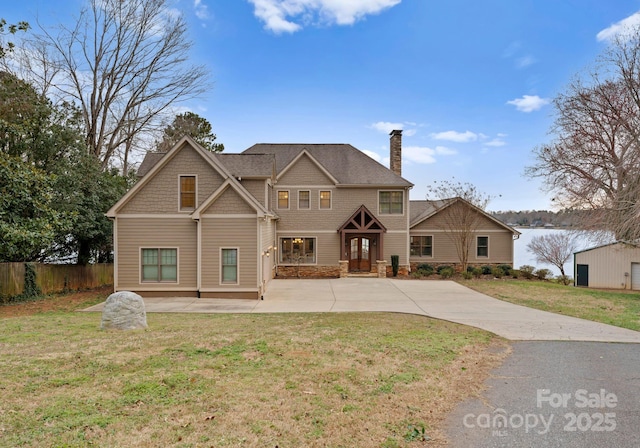 craftsman-style house featuring a front lawn, fence, concrete driveway, a chimney, and a patio area