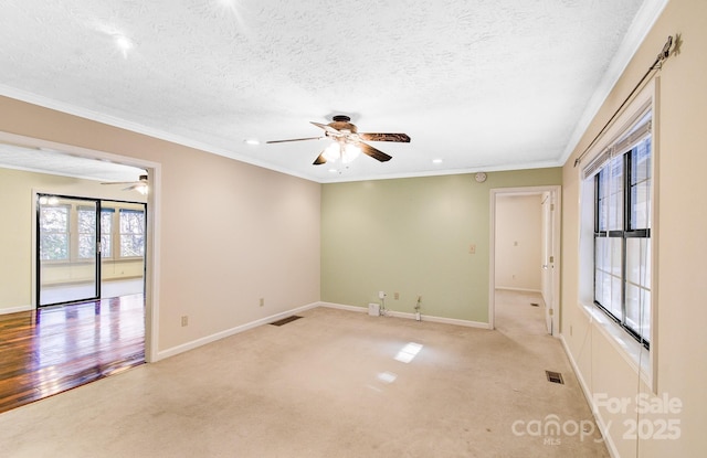 empty room with visible vents, baseboards, and ornamental molding