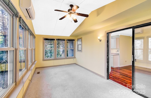 unfurnished sunroom with visible vents, a ceiling fan, vaulted ceiling, and a wall mounted AC