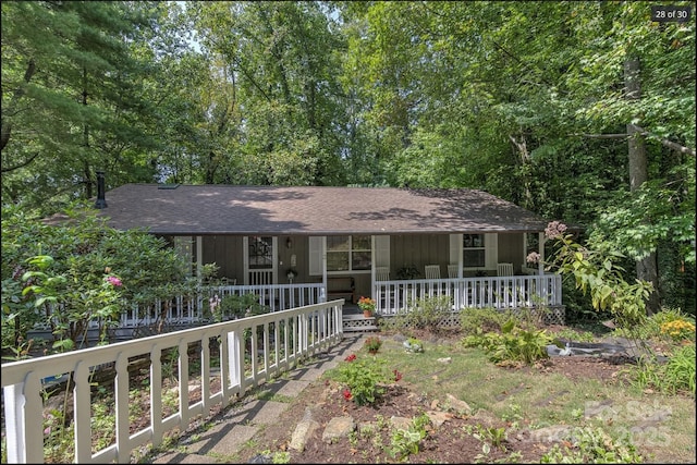 ranch-style home with covered porch and a shingled roof