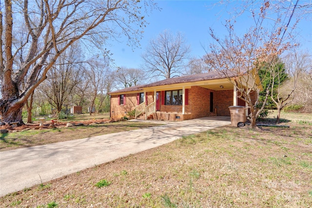 ranch-style home with a front lawn, driveway, crawl space, a carport, and brick siding