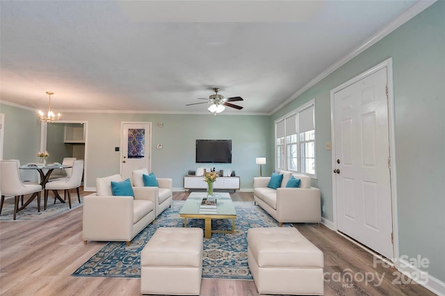 living room featuring crown molding, baseboards, and wood finished floors