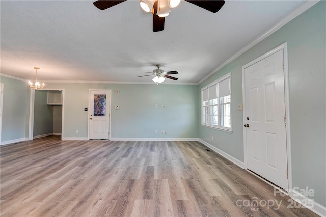 unfurnished living room featuring a notable chandelier, wood finished floors, baseboards, and ornamental molding