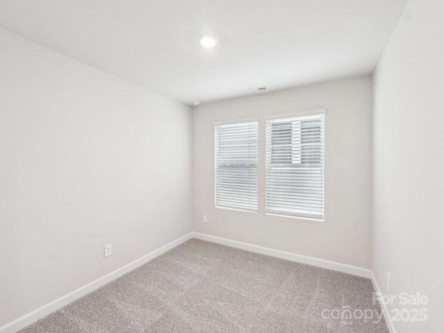 carpeted empty room featuring baseboards