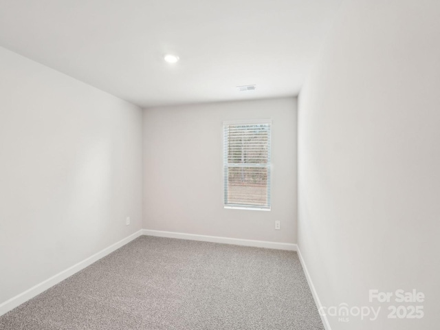 empty room featuring visible vents, baseboards, and carpet floors