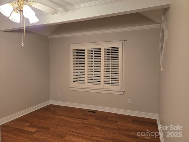 spare room with visible vents, dark wood-type flooring, lofted ceiling, a ceiling fan, and baseboards