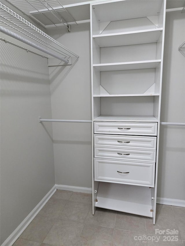 spacious closet with light tile patterned floors