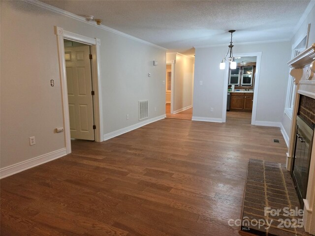 unfurnished living room with crown molding, a fireplace, visible vents, and dark wood-style flooring