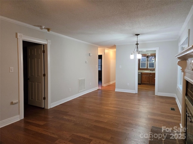 unfurnished living room with visible vents, ornamental molding, a sink, a glass covered fireplace, and dark wood finished floors