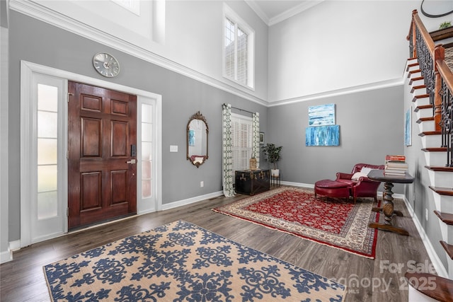 foyer entrance featuring a wealth of natural light, stairway, baseboards, and wood finished floors